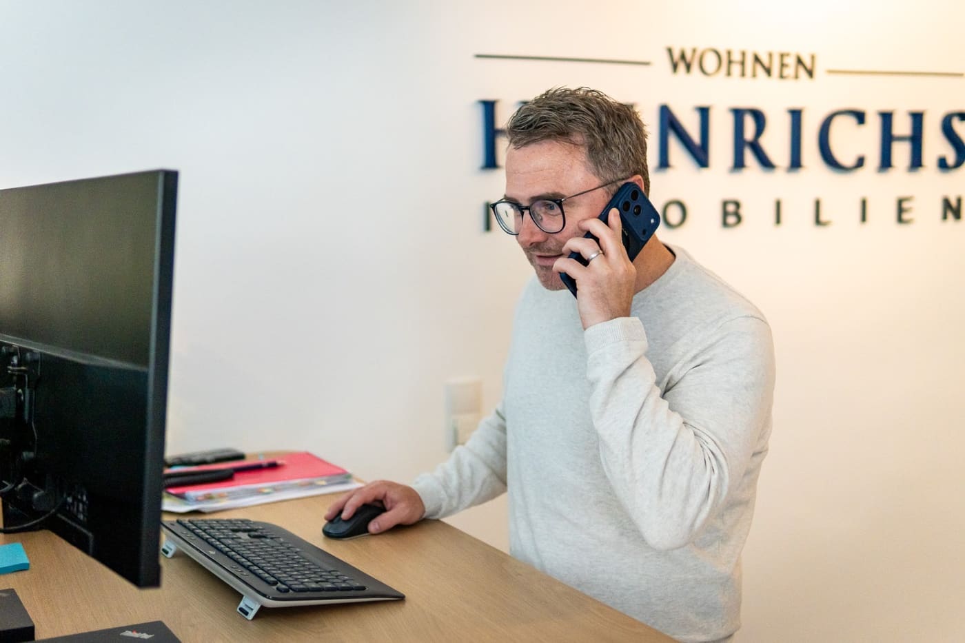 Andreas Heinrichs am Telefon im Büro von Heinrichs Immobilien